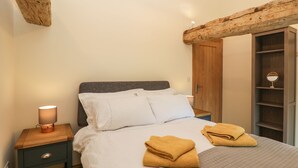 A bedroom with a bed, bedside table, and a wardrobe. - Chequers Barn (Corsham)