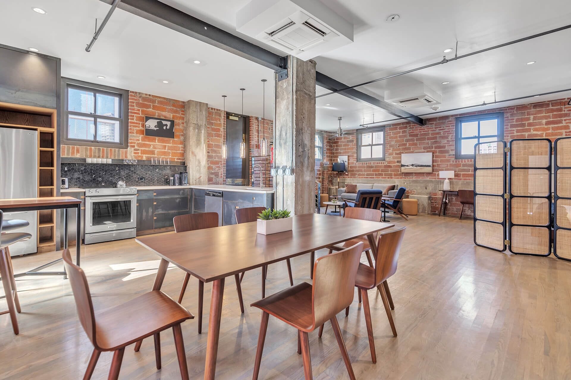 A spacious kitchen with a large island, modern appliances, and a brick accent wall.