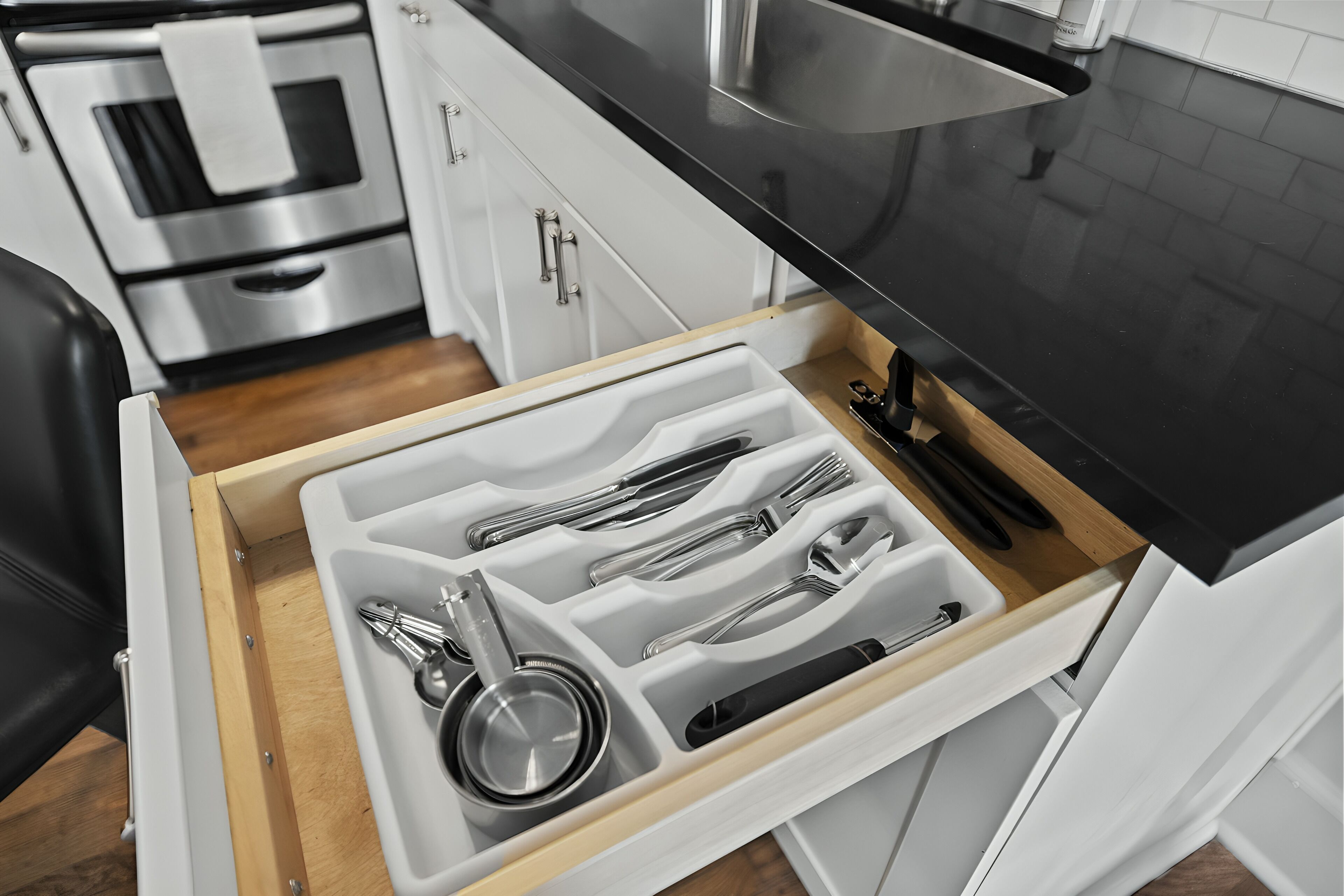 A kitchen drawer with utensils and cookware.