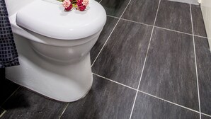 A modern bathroom with a toilet, a sink with plants, and a mirror. - Arte plus KLCC By Tenang Home (Kuala Lumpur)