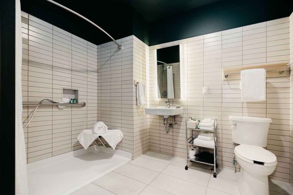 Een moderne badkamer met een bad, wastafel en toilet.