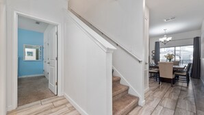 Un escalier menant à une salle à manger offrant une vue sur l’extérieur.