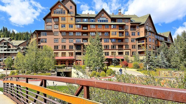 A multi-story hotel with a traditional architectural style, featuring balconies and a central courtyard. - Ski In Ski Out | Zephyr Mountain Lodge 2219 | Hot Tub | Base Area (Winter Park)
