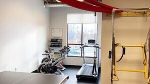 A gym with exercise equipment, a treadmill, and a red curtain. - The Quarters | Suite 5 (Grafton)