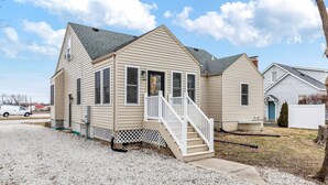 A single-story house with a front porch and a staircase leading to the entrance. - Renovated 5BR | Group Space + Large Yard (Wentzville)