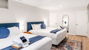A hotel room with two beds, a mirror, a wardrobe, and a patterned rug. - Renovated 5BR | Group Space + Large Yard (Wentzville)
