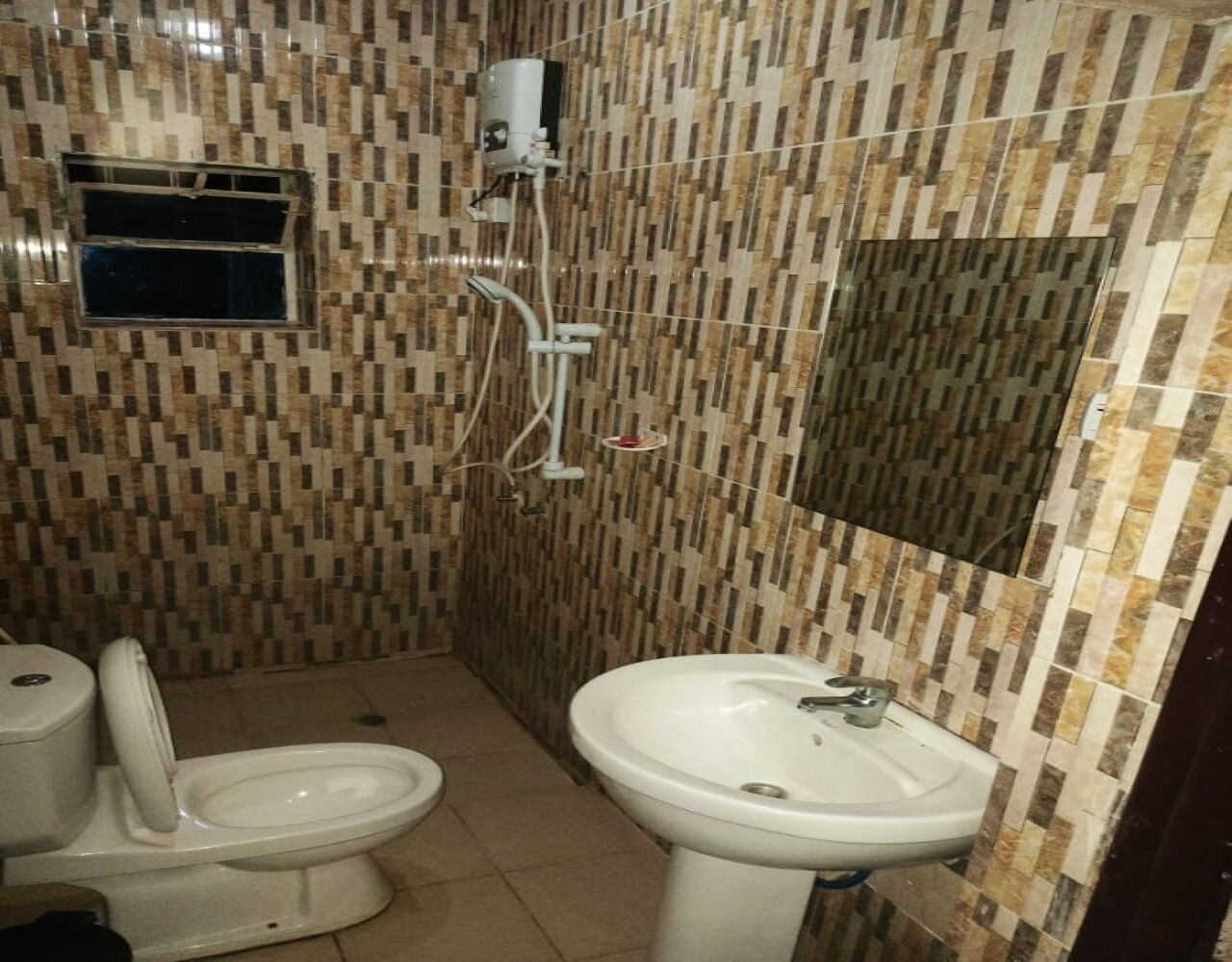 Une salle de bain équipée de toilettes, d’un bidet et d’un lavabo.