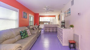 A living room with a sofa, a TV, and a small table.