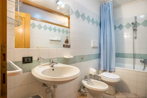 Un baño con lavamanos, inodoro y ducha.