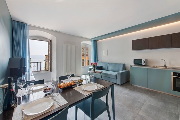 Una sala de estar moderna con comedor, cocina y vista al mar.