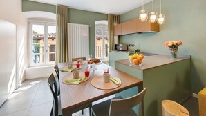 Un coin repas avec une table mise pour le petit-déjeuner, un espace cuisine et une vue sur l’extérieur.