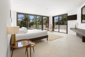 A modern bedroom with a bed, a desk with a lamp, a chair, and large glass doors leading to an outdoor area. - Apartment 'Grand Appartement Valeriane' with Mountain View, Shared Pool and Wi-Fi (Trans-en-Provence)