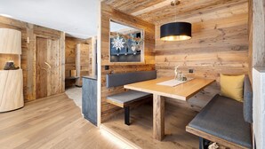 A wooden interior with a bench, table, and hanging pendant light.