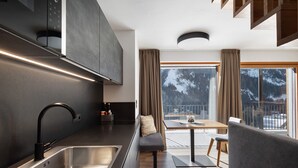 A modern kitchen with a stainless steel sink, a black faucet, and a built-in oven.
