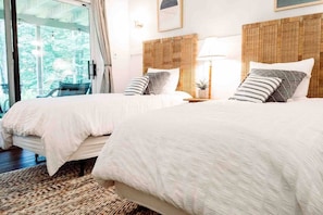 A bedroom with two beds, a large window, and a view of greenery outside. - Cozy Family Cabin • Steps to Lake • Canoe • Firepit • Pet Friendly (Pocono Lake)