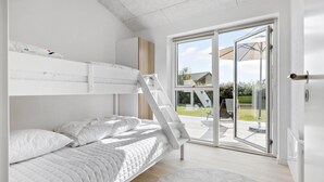 A modern bedroom with a bunk bed, a ladder, and a sliding glass door leading to an outdoor patio. - Cozy home in Haderslev with WiFi (Haderslev)