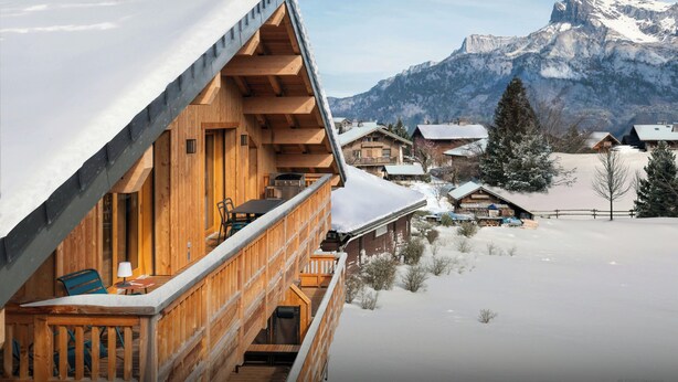 A wooden chalet with a balcony overlooking a snowy landscape and mountains. - Le Primpiolet - Penthouse for 9 with Mont Blanc view - OVO Network (Combloux)