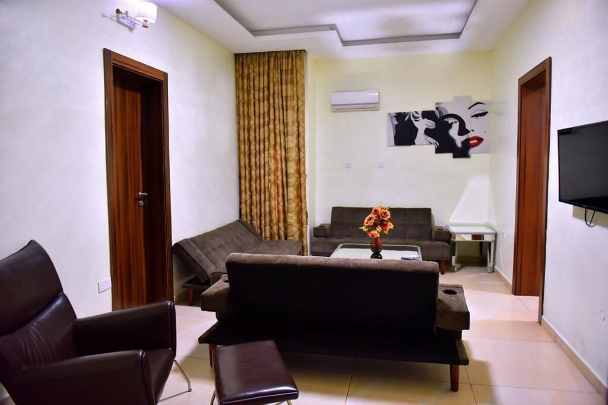 A living room with a sofa, a chair, a coffee table, and a TV.