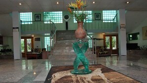 A lobby with a marble floor, a staircase, and a large vase with flowers. - The Dover Hotel Lekki (Lekki)