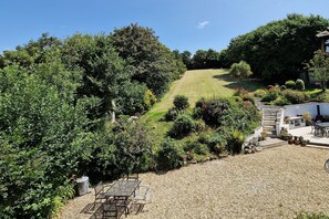 Ein Garten mit Rasenfläche, verschiedenen Pflanzen und Gartenmöbeln.