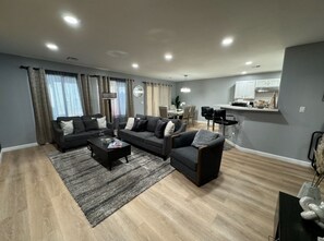 A modern living room with a sofa set, a coffee table, and a dining area with a table and chairs. - 3BR Vegas Home • Near the Strip, Allegiant & Airport • Sleeps 8 (Las Vegas)