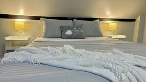 A neatly made bed with a white comforter and lace-trimmed blanket, two bedside lamps, and a pillow with the word "Together". - New, Clean, Downtown Getaway! (Concord)