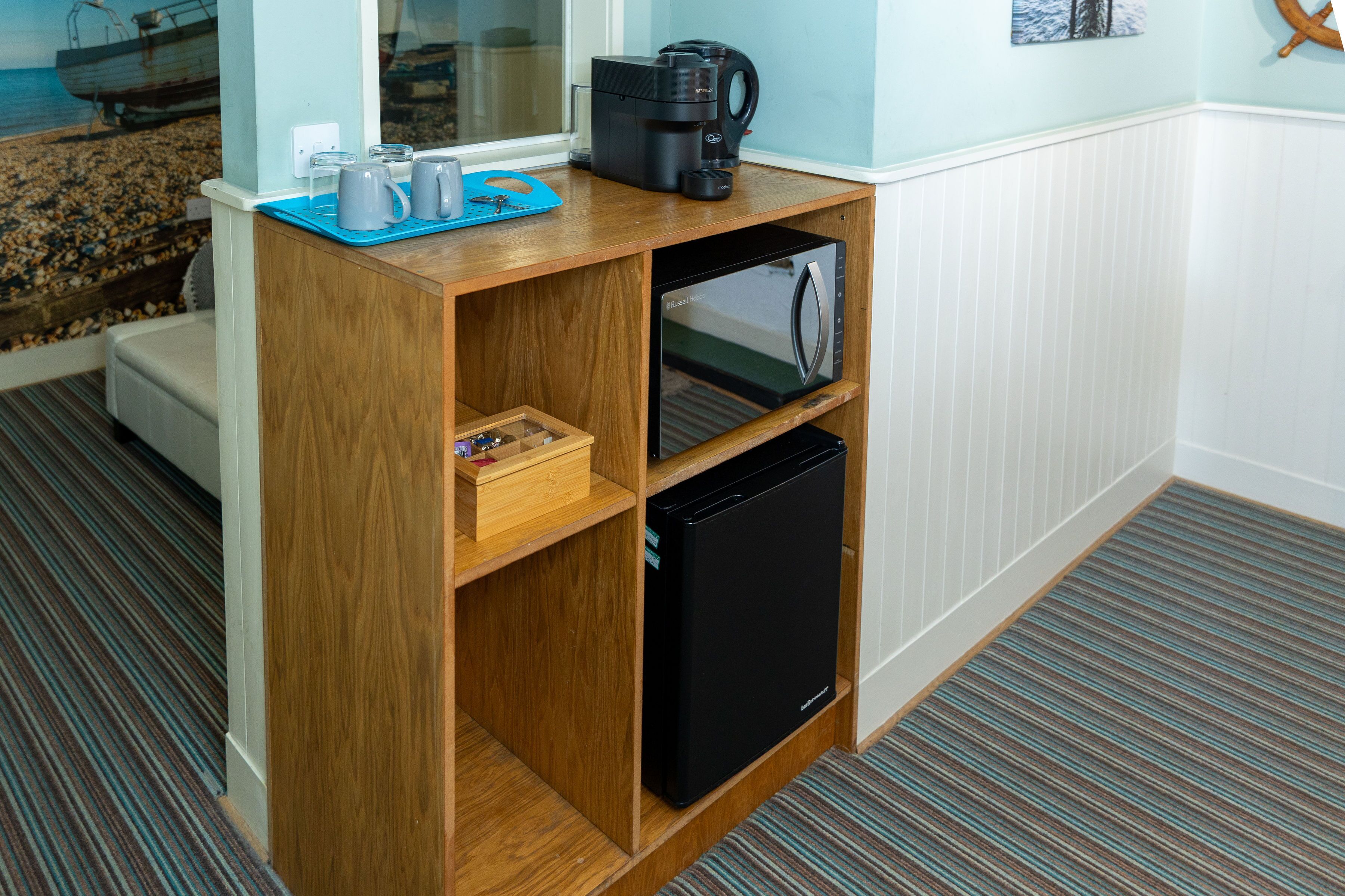A compact kitchenette with a coffee maker, a microwave, and a small refrigerator.
