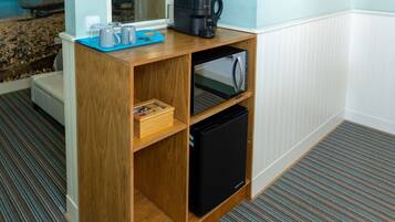 A compact kitchenette with a coffee maker, a microwave, and a small refrigerator.