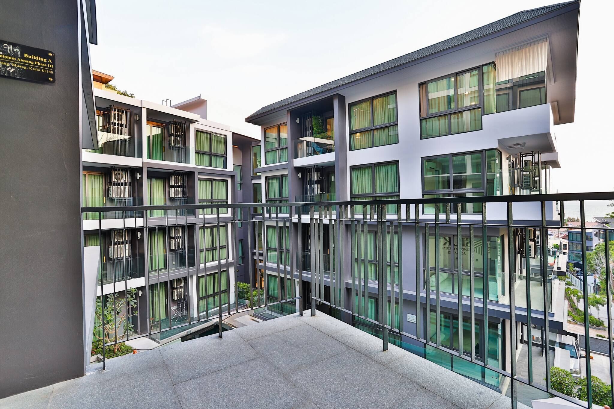 Un edificio moderno de varios pisos con balcones, ventanas grandes y un cartel que indica que es el Edificio A.