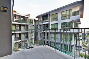 A modern multi-story building with balconies, large windows, and a sign indicating it is Building A.