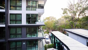 A modern multi-story building with large windows and a car parked in the driveway. - Bo202- 1 Bedroom Condo With Sea View Ao Nang Beach (Krabi)
