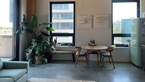 A modern kitchen with a wooden ceiling, large windows, a dining table with chairs, and a refrigerator. - Gorgeous two bedroom with a huge terrace (Brooklyn)