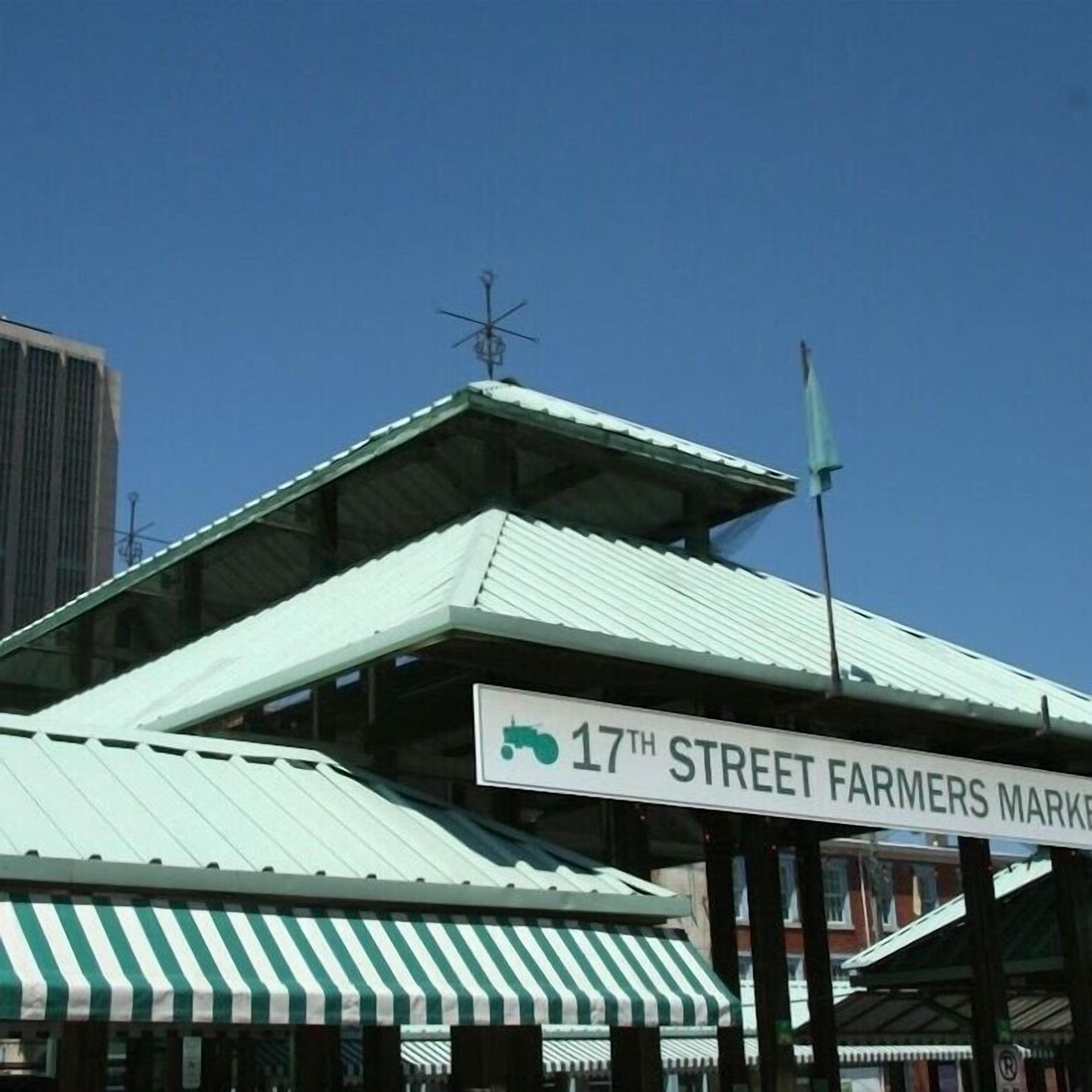 En bygning med grønt tag og et skilt, der viser '17th Street Farmers Market'.
