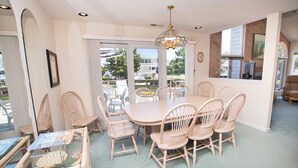 A dining area with a round table and six chairs, large windows, and a chandelier. - Oceanside, Community Pools, Community Tennis, 628,  Corolla Time (Corolla)