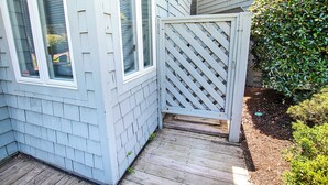 A wooden deck leading to a house with a lattice gate, a window, and a well-maintained hedge. - Oceanside, Community Pools, Community Tennis, 628,  Corolla Time (Corolla)