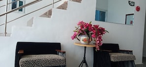 A modern interior with a staircase, two chairs with leopard print upholstery, and a table with a vase of pink flowers. - B Boutique Hotel Cebu powered by Cocotel (Lapu-Lapu)