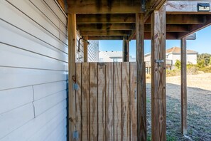 Une porte en bois mène à un porche abrité d’où l’on peut admirer les immeubles d’habitation qui se dressent à l’arrière-plan.