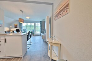 A modern kitchen with a dining area, a large window, and a view of the outdoors. - Seesternresidenz Appartement 21 - Seesternresidenz (Scharbeutz)