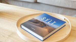 A book titled 'SYLT' on a wooden tray.