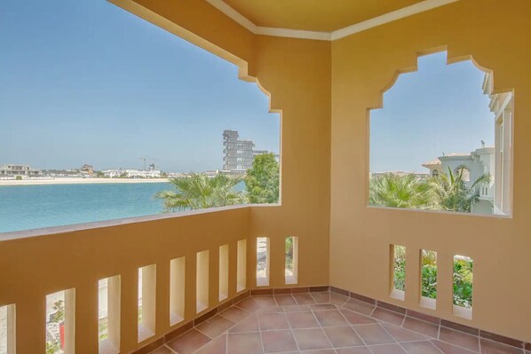 Ein Balkon mit Blick auf das Meer und Gebäude.