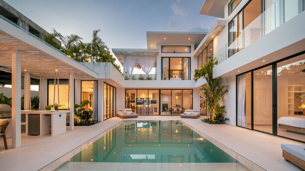 A modern house with a central swimming pool, outdoor seating, and a well-lit interior.