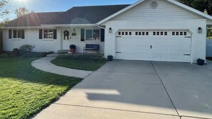 A single-story house with a garage, a front porch, and a well-maintained lawn. - Spacious Family Home • Game Room • Pets Welcome (Orem)