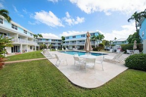Um hotel com piscina, área de estar ao ar livre e gramado bem cuidado.