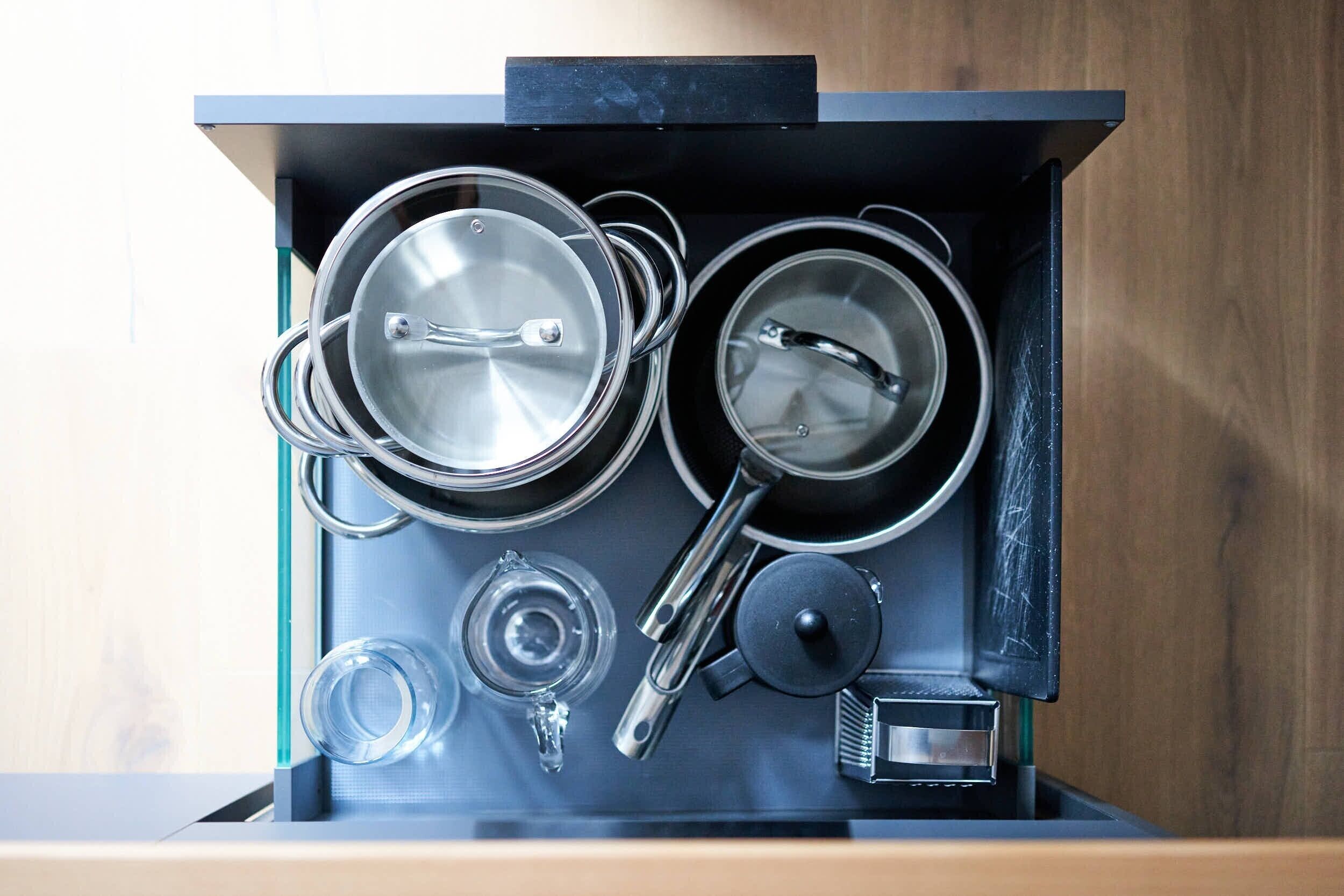 Une cuisine équipée de casseroles, de poêles, d’une bouilloire et d’une machine à café.