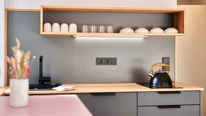 A modern kitchen with a wooden countertop, a kettle, and a shelf with jars. - Guest House 'Alte Seifensiederei - Malala' with Shared Terrace, Shared Garden and Wi-Fi (Bad Tölz)