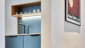 Eine moderne Küche mit blauen Schränken, einer Holz Arbeitsplatte und einem gerahmten Bild an der Wand.