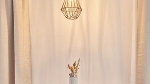 A wooden dining table with two chairs, a hanging light fixture, and a vase with dried flowers. - Guesthouse 'Alte Seifensiederei – Viktor' with Shared Terrace, Garden & Wi-Fi (Bad Tölz)