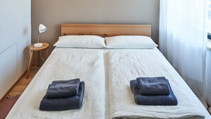 Ein Schlafzimmer mit einem Doppelbett, zwei Nachttischen, einer Wandlampe und einer Pendelleuchte.