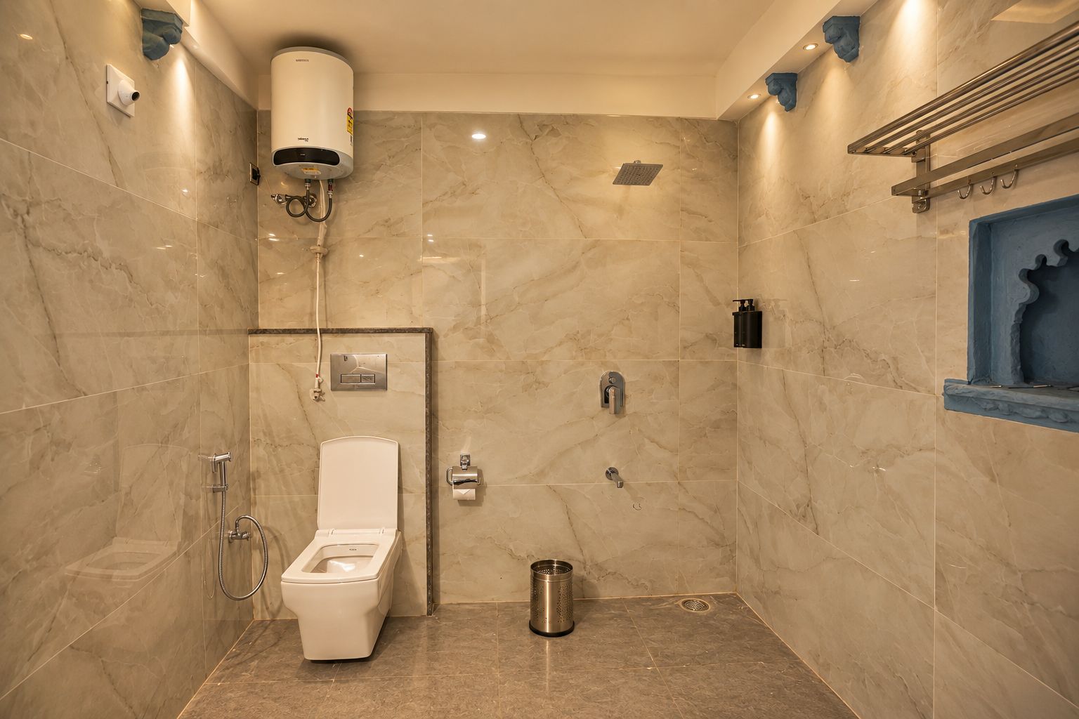 Une salle de bain équipée de toilettes, d’une douche et d’un sèche-mains.