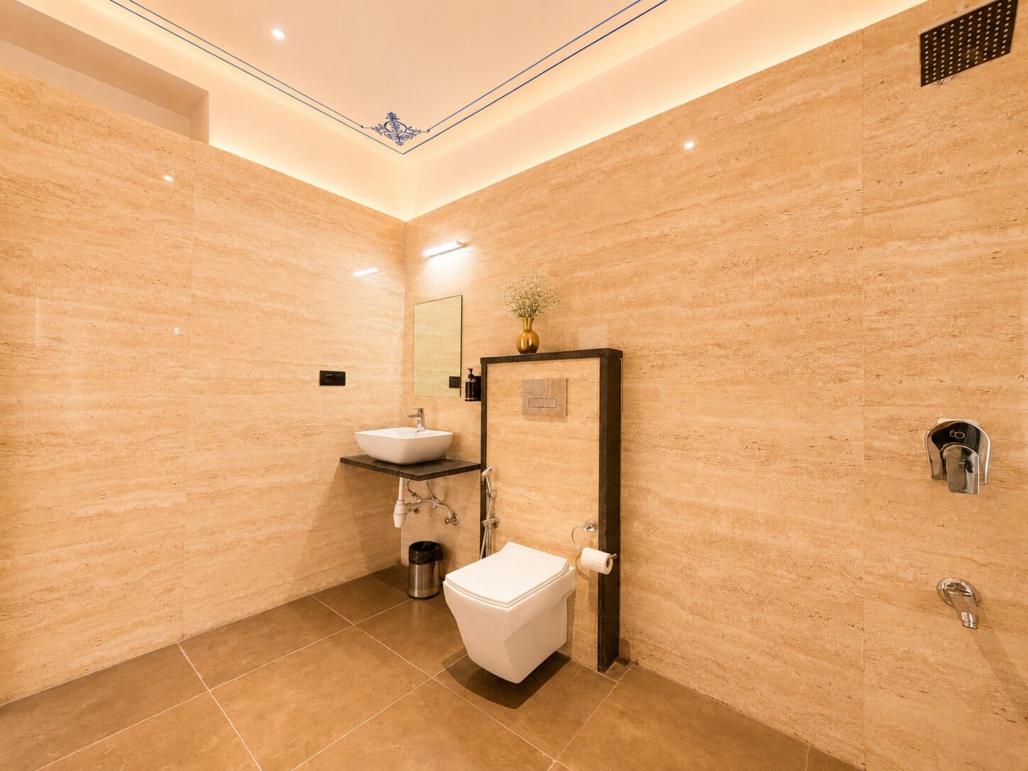 A modern bathroom with a white sink, toilet, and a large mirror.